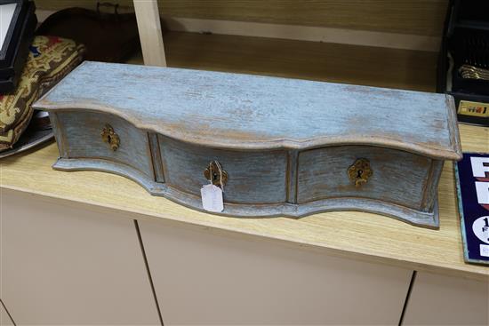 A three drawer serpentine table top cabinet and a woolwork cushion